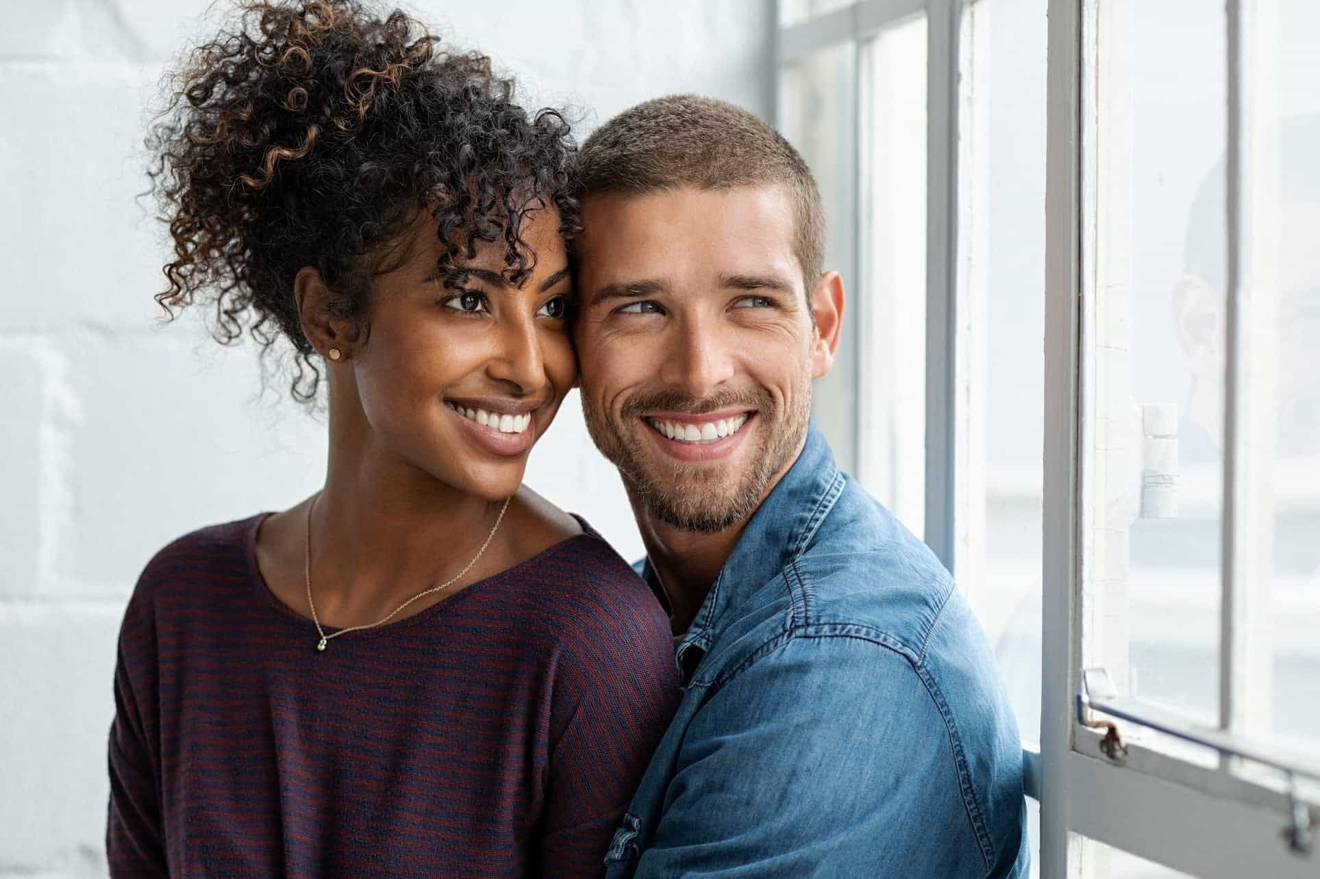 a man and woman smiling and hugging