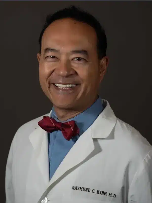 a man in a white coat and a red bow tie