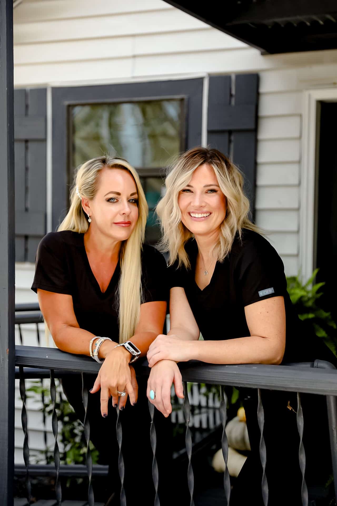two women leaning on a railing