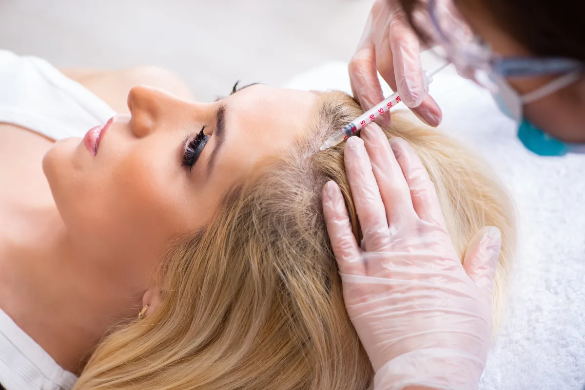 a woman receiving a hair loss treatment