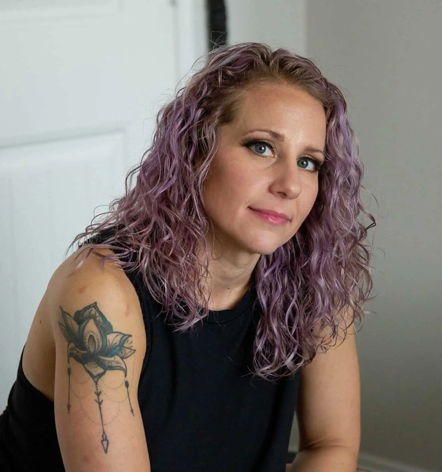 a woman with purple hair and tattoo on her arm