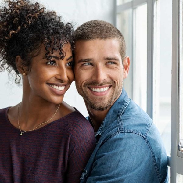 a man and woman smiling and hugging